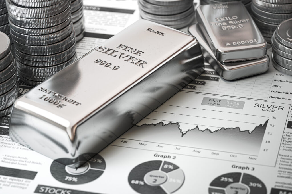 Graafi näyttää hopean hinnan ennusteen vuodelle 2024, rinnalla hopeaharkkoja kuvastamassa hopean fyysistä arvoa ja hopean muuttamista rahaksi.